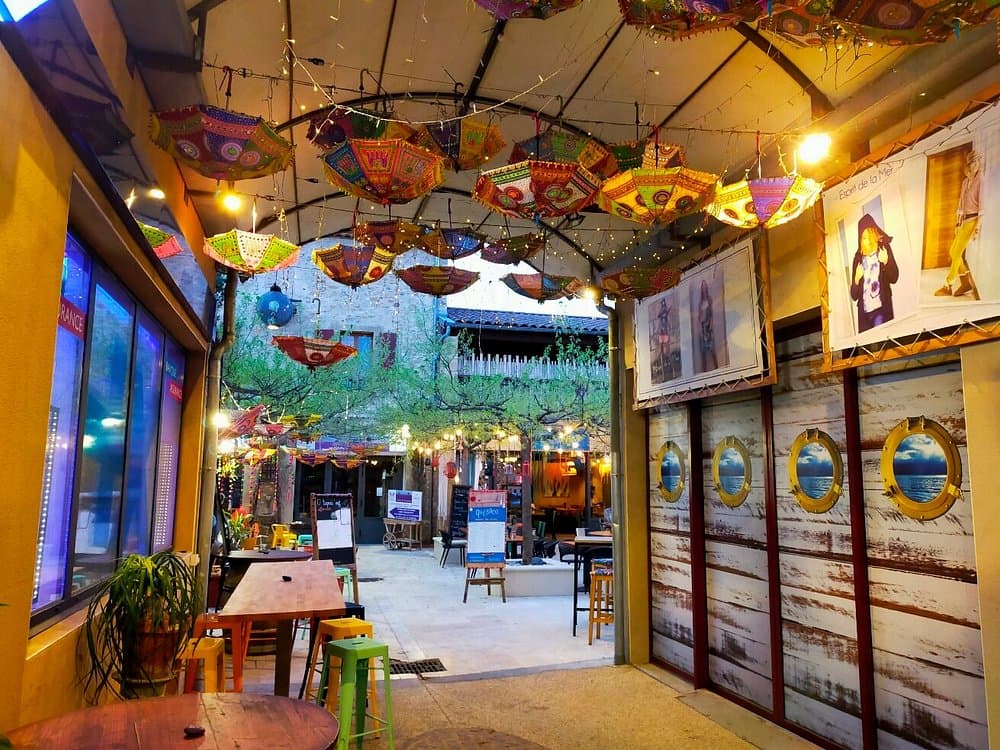 Entrée du Quésaco avec son plafond couvert d'ombrelles indiennes colorées