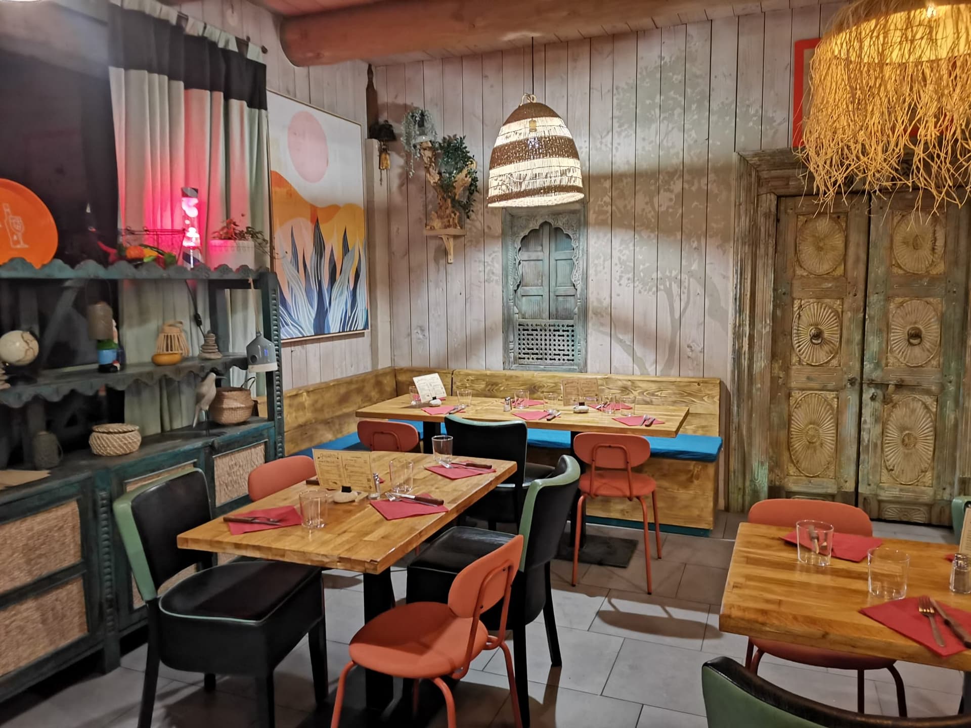 Banquette intérieure avec coussins bleus et peinture murale colorée