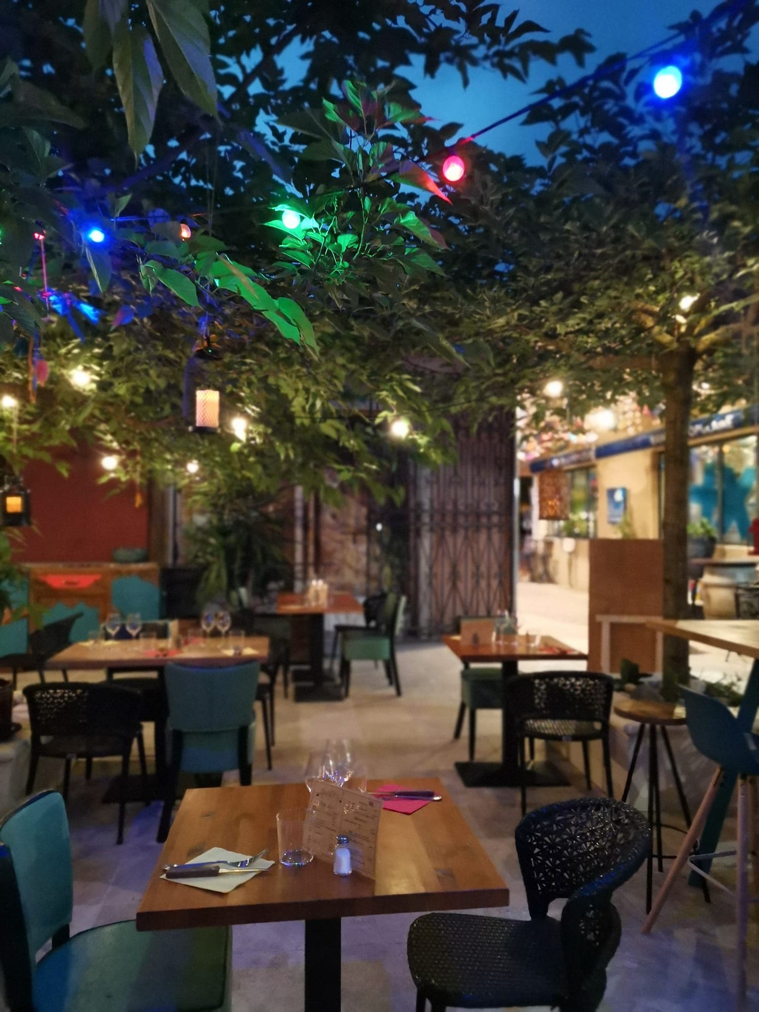 Terrasse du Quésaco la nuit, illuminée par des guirlandes lumineuses colorées
